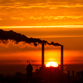 e levanta detrás de las chimeneas de billowing de la central eléctrica en Berlín/REUTERS