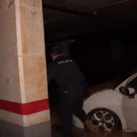 Los agentes revisan coche a coche aparcamientos inundados en Benetúser