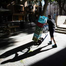 Un trabajador acarrea unas cajas por el centro del Palma de Mallorca. AFP/JAIME REINA