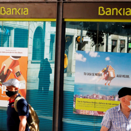 Una oficina de Bankia en Barcelona, en cuyas ventanas se refleja una sucursal cercana de Caixabank. REUTERS/ Albert Gea