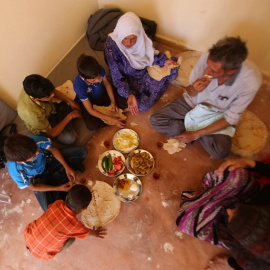 Una familia siria que tuvo que huir de la ciudad de Daraya se reúne para desayunar en una pequeña habitación a las afueras de damasco. - AFP