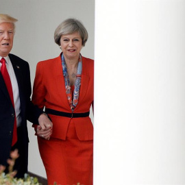 El presidente de EEUU, Donald J. Trump, pasea de la mano con la primera ministra británica, Theresa May, entre las columnas de la Casa Banca. EFE/EPA/Olivier Douliery
