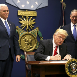 El presidente Donald Trump firma la orden que establece un control extremo de las personas que llegan a Estados Unidos después de asistir al juramento del secretario de Defensa, James Mattis (R), con el vicepresidente Mike Pence en Washingt