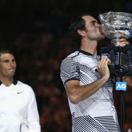 Rafa Nadal observa a Roger Federer besando el trofeo de campeón del Open de Australia. /REUTERS