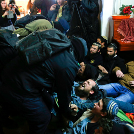 Los policías israelíes tratan de retirar activistas pro-asentamientos de una casa en el desalojo de Amona/ REUTERS
