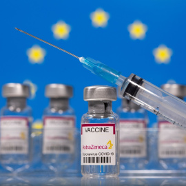 Un vial de vacunas etiquetado con el nombre de Astra-Zeneca, con una jeringuilla, y la bandera de la UE al fondo. REUTERS/Dado Ruvic/Ilustración