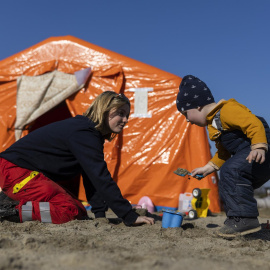  Una voluntaria juega con un niño este lunes en el campamento de refugiados en Budomierz (Polonia), en el paso fronterizo con Ucrania más cercano al bombardeo del IPSC de Yavoriv, a 25 kilómetros de la frontera polaca. EFE/Rodrigo Jiménez
