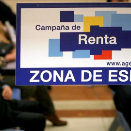 Contribuyentes esperan a ser atendidos en una oficina de la Agencia Tributaria durante la Campaña de la Renta. EFE