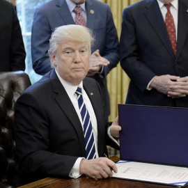 El presidente de EEUU, Donald J. Trump, firma el documento que desmantela el sistema financiero descrito en la Ley Dodd-Frank. - EFE