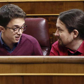 El líder de Podemos, Pablo Iglesias (d), conversa con el portavoz parlamentario de esta formación, Íñigo Errejón, en el hemiciclo del Congreso. | FERNANDO ALVARADO (EFE)