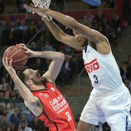 El ala pivot del Valencia Basket, Pierre Oriola (i), intenta encestar ante la defensa del pivot estadounidense del Real Madrid, Anthony Randolph, durante el encuentro correspondiente a la final de Copa del Rey, que disputan esta tarde en el