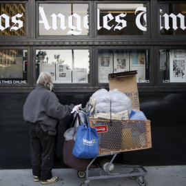 Un hombre lee el 'Los Angeles Times' mientras pasa por el edificio del propio. REUTERS