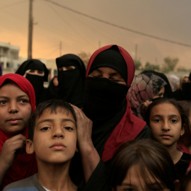Refugiados hacen cola junto a las controles antes de ser evacuados de la 'Jungla' de Calais.  REUTERS/Philippe Wojazer