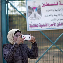 Una mujer hace una foto en el colegio de la comunidad de Jan al Ahmar. EFE/Atef Safadi
