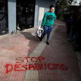Una mujer abandona su domicilio en la localidad madrileña de Parla después de haber sido sesahuciada. REUTERS/Juan Medina