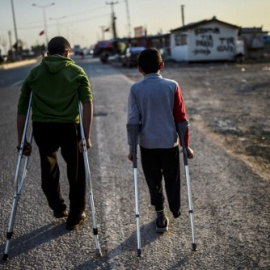 Dos niños sirios heridos pasean por un campamento de refugiados en Kilis, en el centro-sur de Turquía. - AFP