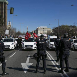 Agentes de la Policía Nacional vigilan durante la manifestación de los taxistas por el centro de Madrid. | SANTI DONAIRE (EFE)