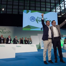 El presidente del Gobierno, Mariano Rajoy (d), y el líder del PP andaluz, Juanma Moreno (i), saludan tras finalizar la intervención del jefe del Ejecutivo, durante la clausura del 15 Congreso Autonómico del Partido Popular que se ha celebra