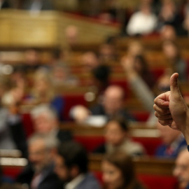 Un diputado indica el sentido del voto a su grupo durante la votación en el Pleno del Parlament de los Presupuestos catalanes para 2017. REUTERS/Albert Gea