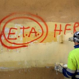 Un trabajador municipal borra un graffiti en el que se podía leer "ETA, la gente está contigo" en el pueblo vasco de Guernica, el día después que la banda terrorista anuncaria el cese de sus actividades en 2011.REUTERS/Vincent West