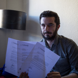 Guillermo, uno de los inquilinos, posa en el salón de su casa con varios de los burofaxes con los que Urbania le exige que abandone el domicilio.- JAIRO VARGAS