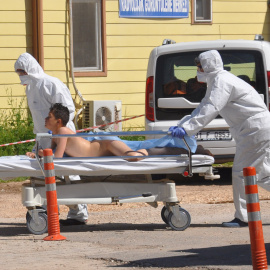 Médicos turcos con trajes de protección trasladan a un herido en el ataque químico a Idlib (Siria). /REUTERS