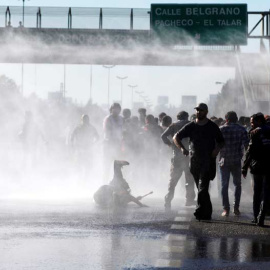 Varios manifestantes son reprimidos con mangueras de agua durante la jornada de huelga general en Argentina. | REUTERS