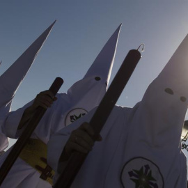 Nazarenos de la cofradía de San Gonzalo en el puente de Triana en esta calurosa tarde del lunes santo. EFE/Raúl Caro