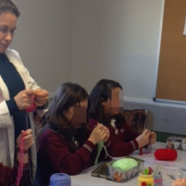 Una de las profesoras voluntarias impartiendo una clase de ganchillo en el colegio Juan Pablo II de Alcorcón. JUAN PABLO II ALCORCÓN