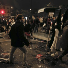 Nazarenos de La Esperanza de Triana ante el descontrol tras sufrir una estampida durante su recorrido procesional a su paso por el puente de Triana, esta noche durante la Madrugá de Sevilla. EFE/José Manuel Vidal