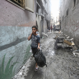 Un niño palestino sale con sus pertenencias del campo de refugiados de Al-Shati en Gaza tras un ataque aéreo israelí. -MOHAMMED TALATENE / Europa Press