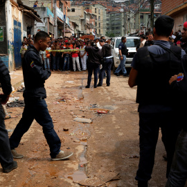 Policías e investigadores buscan evidencia frente a una panadería saqueada en Caracas. REUTERS / Carlos Garcia Rawlins