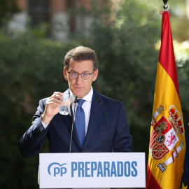El presidente del PP, Alberto Núñez Feijóo, bebe agua durante su comparecencia para hacer balance del curso político E.P./Marta Fernández