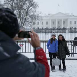 Unos turistas se fotografian frente a la Casa Blanca, llena de nieve. /REUTERS