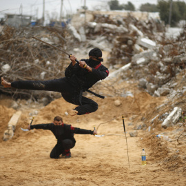 Jóvenes palestinos salta con una espada al estilo del ninja en el norte de la Franja de Gaza. REUTERS/Mohammed Salem