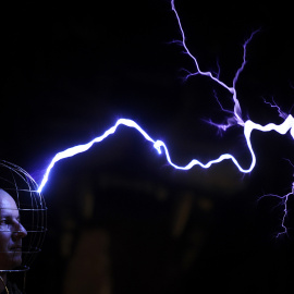 Oleg Melnik lleva un casco de alambre mientras descargas eléctricas en el Elemento Science Museum en Minsk. SERGEI GAPON/AFP