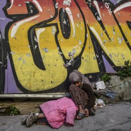 Una chica siria mendiga en la calle mientras otro niño duerme a su lado, en el centro de Estambul. BULENT KILIC / AFP