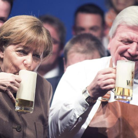 La canciller alemana, Angela Merkel y el primer ministro de Hesse, Volker Bouffier, beben una cerveza durante el tradicional encuentro que celebra cada Miércoles de Ceniza la Unión Cristianodemócrata (CDU), en Volkmarsen, Alemania. EFE/Swen