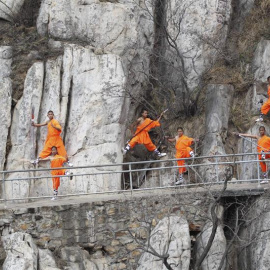 Practicantes de Kung fu de una escuela local de artes marciales demuestran sus habilidades en un acantilado cerca del Templo Shaolin en Dengfeng, China. EFE