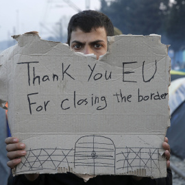 Un refugiado sostiene un mensaje en un campamento improvisado en la frontera entre Grecia y Macedonia, cerca de la localidad de Idomeni.  REUTERS/Alkis Konstantinidis TPX IMAGES OF THE DAY