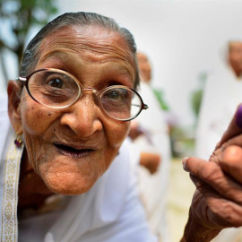 Una anciana india muestra su dedo marcado con tinta tras votar en la primera fase de las elecciones a la Asamblea de Assam, en el distrito de Jorhat, dentro del estado indio de Assam. EFE/Str