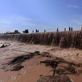Varias personas cruzan una carretera inundada a las afueras de Peshawar en Pakistán. Las autoridades paquistaníes continúan con las tareas de rescate de 23 personas atrapadas en viviendas dañadas en la provincia de Khyber Pakhtunkhwa, en el