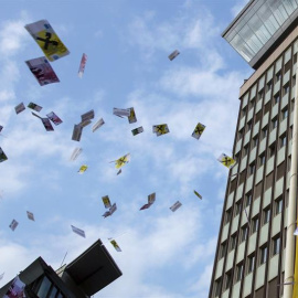 Decenas de personas lanzan falsos billetes en el aire durante una protesta contra el blanqueo de capitales, frente a la sede del banco Raiffeisen, en Viena, Austria. EFE/Christian Bruna