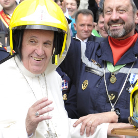 El Papa Francisco se pone el casco de los bomberos de París al final de su audiencia en el Vaticano. REUTERS/Osservatore Romano Handout via Reuters