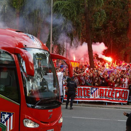 Cientos de aficionados del Atlético, algunos con bengalas, al paso del autobús de su equipo. /EFE