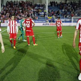 Los jugadores del Sporting se marchan desolados de Ipurúa. /EFE