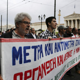 Varios activistas del sindicato comunista PAME corean consignas durante la huelga general de 24 horas contra los últimos recortes pactados con la UE. EFE/Alexandros Vlachos