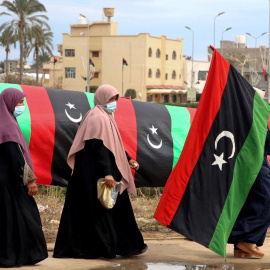 Una mujer libia porta una bandera nacional en la capital, Trípoli, el 25 de febrero de 2021.