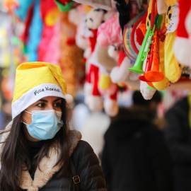 Una mujer con un gorro de Papa Noel y una mascarilla, el mismo día que entra en vigor la obligatoriedad de usar mascarilla en exteriores, a 24 de diciembre de 2021, en Madrid.