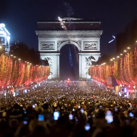 Personas celebran el año nuevo en los Campos Elíseos de París, Francia, el 1 de enero de 2022.